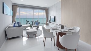 A modern hotel room with a balcony, a dining area, and a living space. - White Sand Beach Residences Pattaya (Sattahip)