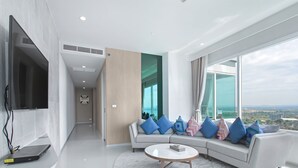 A modern living room with a sofa, coffee table, and a TV. - White Sand Beach Residences Pattaya (Sattahip)