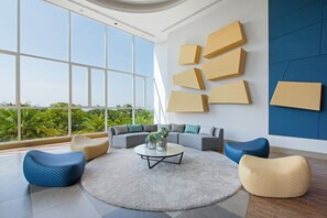 A modern living room with a large window, a sectional sofa, and a coffee table. - White Sand Beach Residences Pattaya (Sattahip)