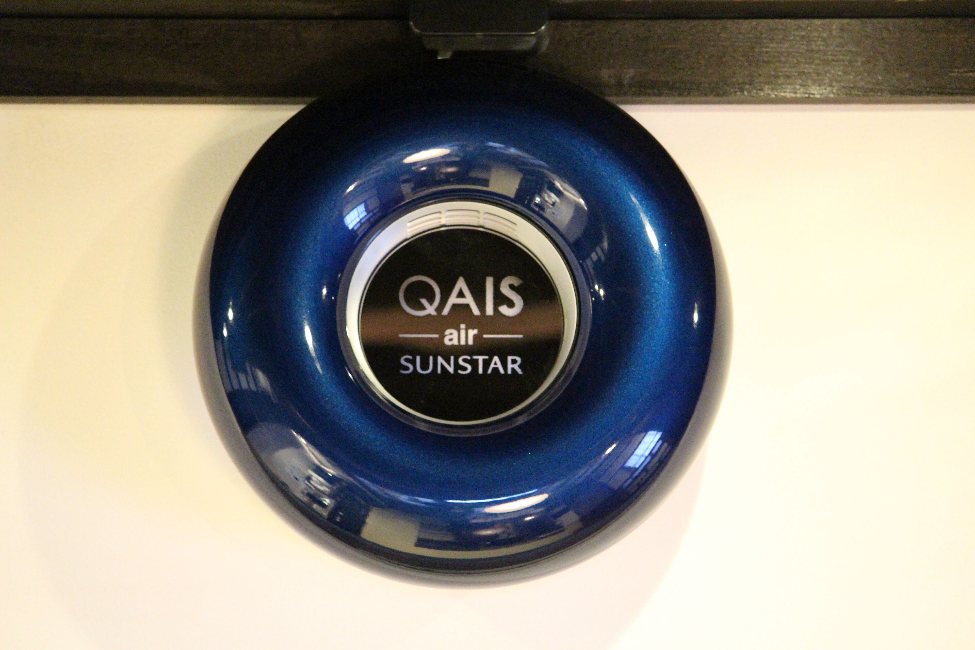 Een blauw, rond object met de tekst 'QAIS air SUNSTAR'.