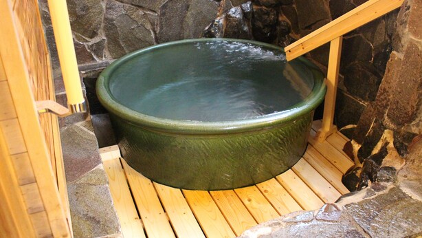 A stone-walled hot tub with a wooden bench and a wooden ladder. - Hakodate Classic Hotels (Hakodate)