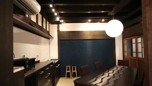 A modern kitchen with dark cabinetry, a built-in oven, and a countertop with a coffee machine. - Hakodate Classic Hotels (Hakodate)