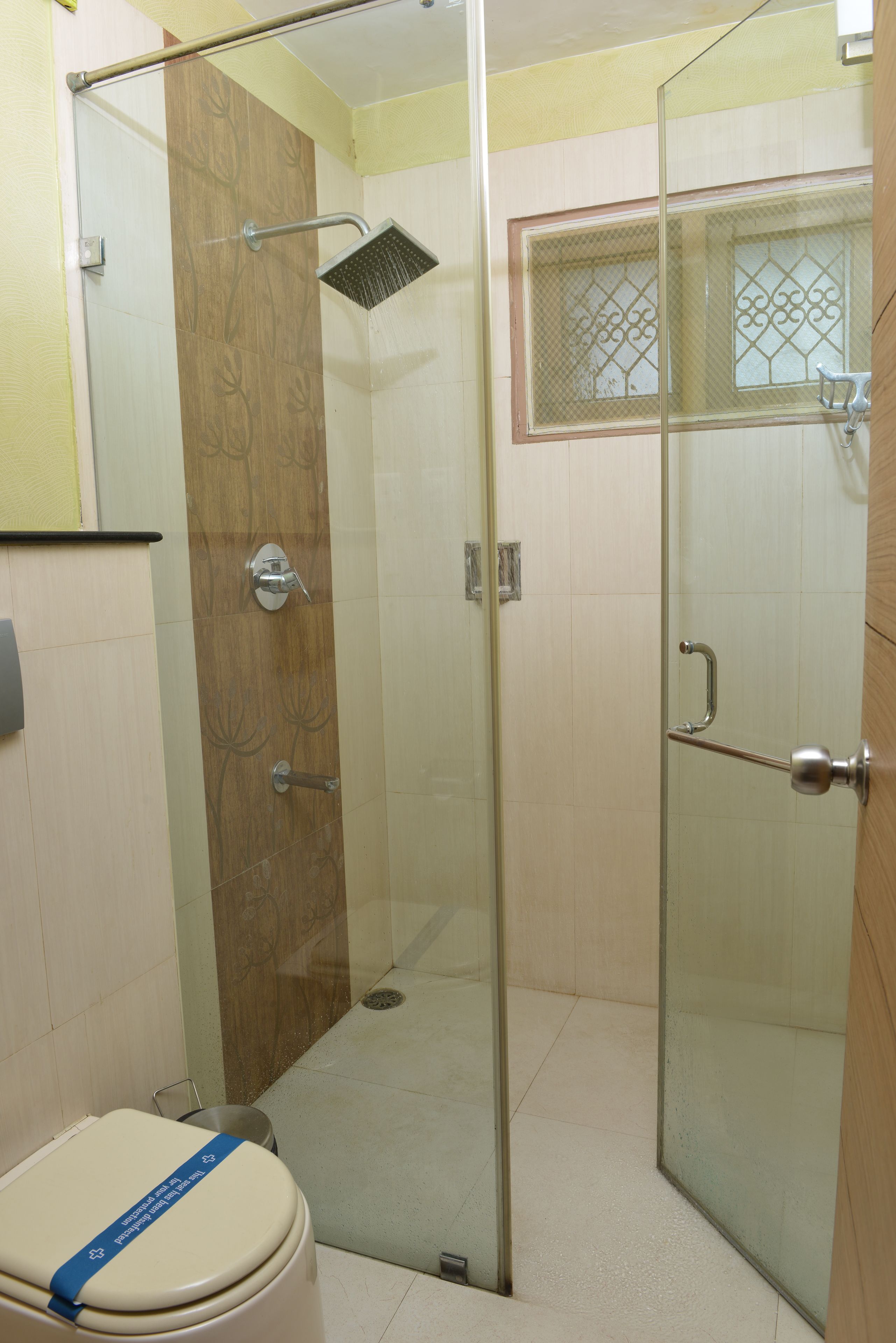 A bathroom with a glass-enclosed shower, a toilet, and a sink.