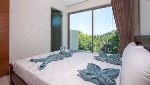 A hotel room with a large bed, a window with curtains, and a view of greenery outside. - 2 Bedroom Pool Villa with Waterfall View SDV006-By Samui Dream Villas (Koh Samui)