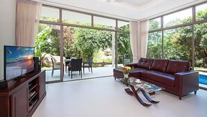 A spacious living room with a large TV, a leather sofa, and a coffee table. - 2 Bedroom Pool Villa with Waterfall View SDV006-By Samui Dream Villas (Koh Samui)