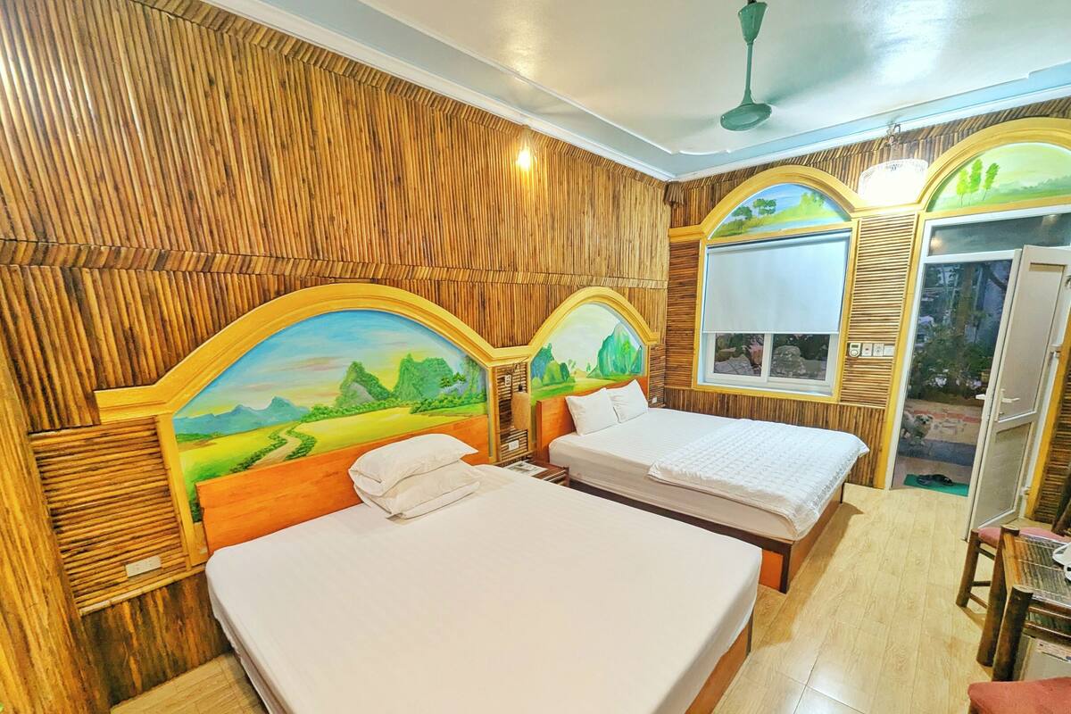 Une chambre avec deux lits, un lambris en bois et une fresque sur la tête de lit.