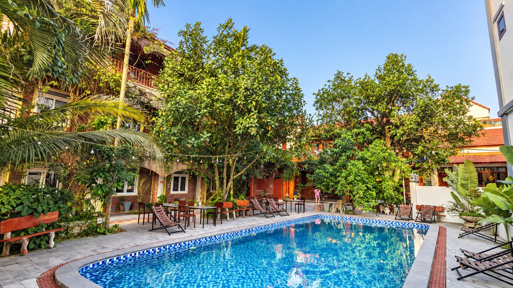 A swimming pool surrounded by lush greenery and outdoor seating.