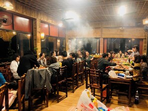 A restaurant with wooden furniture and a high ceiling.