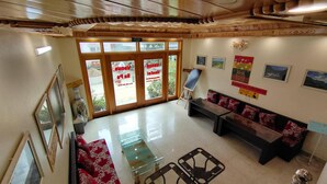 A hotel lobby with a reception desk, seating area, and large windows. - Sa Pa Venus - Hostel (Sa Pa)