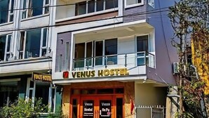 A multi-story building with a sign reading "VENUS HOSTEL" at the ground level. - Sa Pa Venus - Hostel (Sa Pa)