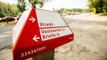 A directional sign with arrows and text indicating directions to 'Oostvoorne 7,2' and 'Brielle 11'.