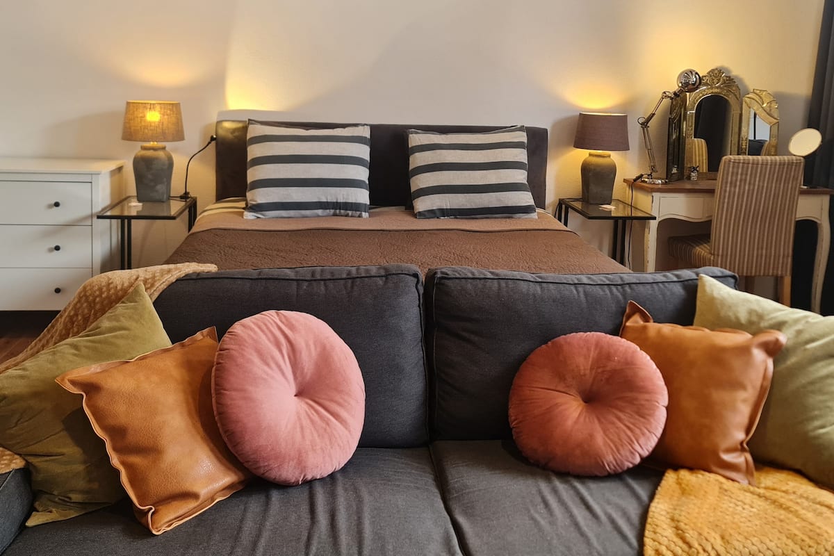 Une chambre moderne avec un grand lit, deux tables de chevet, un bureau et une chaise.