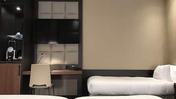 Een hotelkamer met een bed, een bureau, een stoel, een televisie en een minibar.
