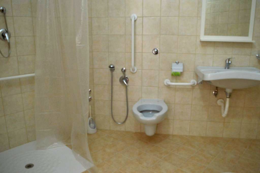 Un baño con inodoro, bidé, ducha y lavamanos.