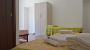 A bedroom with a bed, two bedside tables, a wardrobe, and a door. - B&B Scalea Rooms (Scalea)