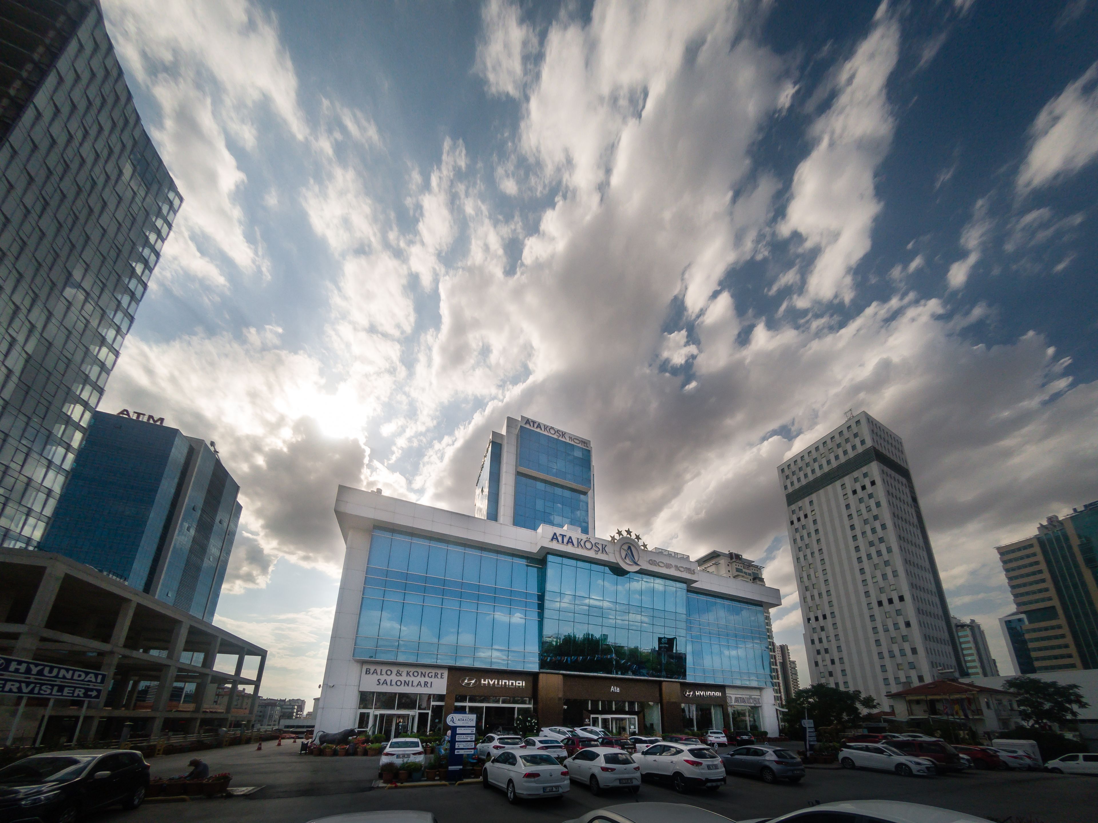 A modern hotel with a glass facade, multiple floors, and a prominent AT&T sign.