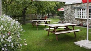 Ein Außenbereich mit Picknicktischen und einem Zelt von Stella Artois.