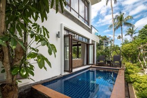 Una casa moderna con piscina, ventanas amplias y un balcón con mobiliario exterior.