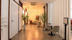 A hotel corridor with a reception area, seating, and potted plants. - Anyang CNC Hotel (Anyang)
