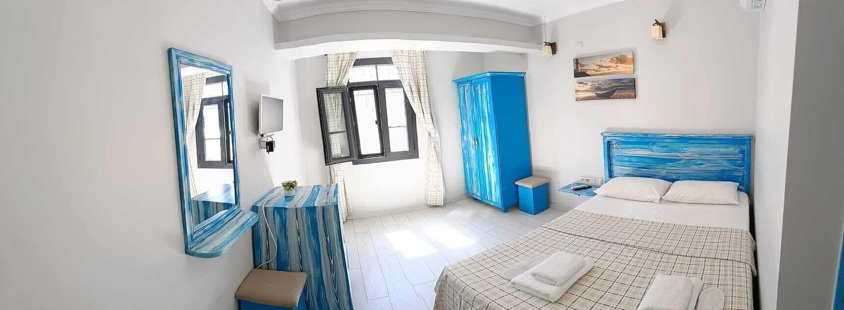 Quarto com cama, espelho, guarda-roupa e uma pequena mesa.