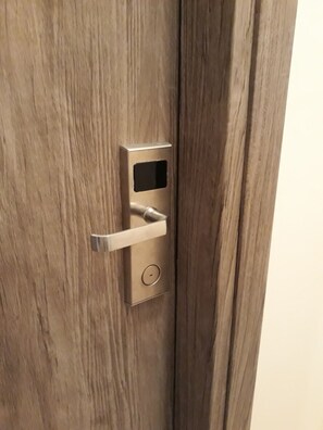 A wooden door with a modern electronic lock and a keyhole. - Kallisto Studios (East Mani)