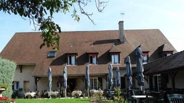 A building with a sloped roof, multiple windows, and outdoor seating with umbrellas. - Hôtel Restaurant Le relais de la Sans Fond (Fenay)