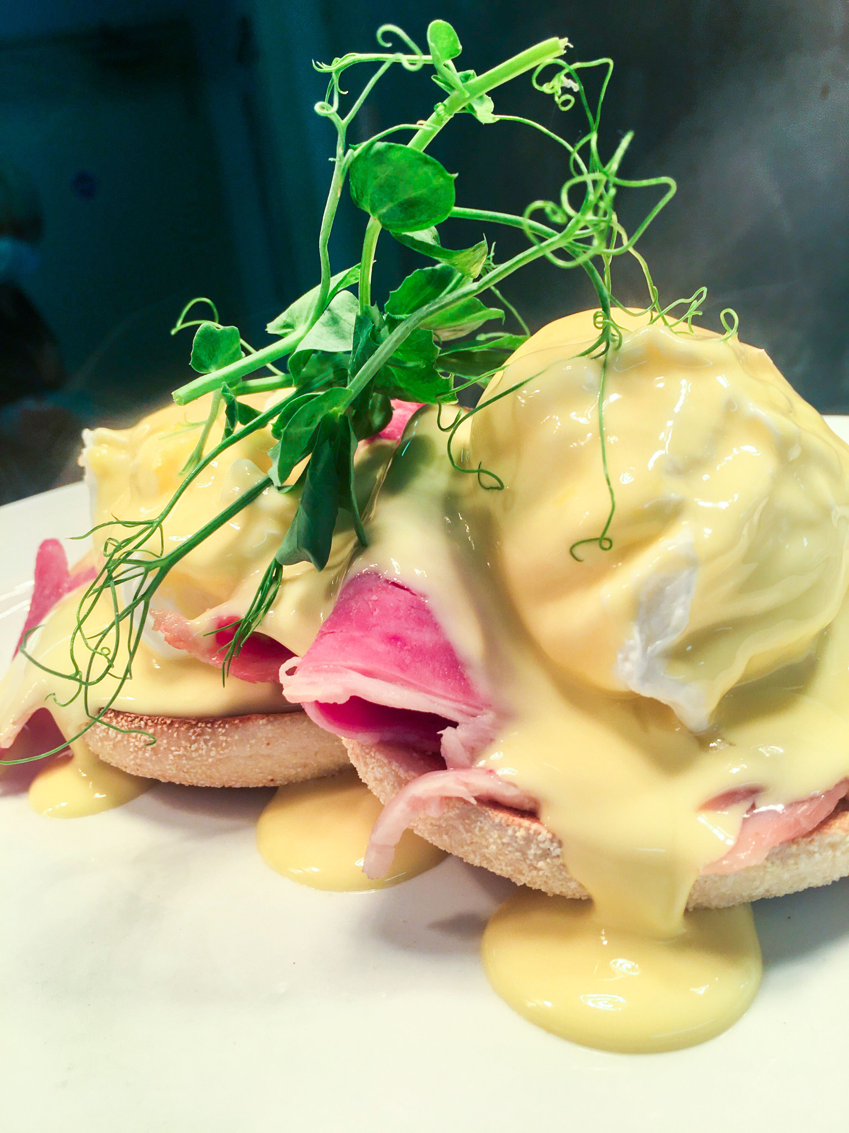 A breakfast dish with eggs, ham, and greens.