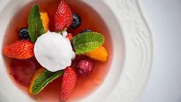 Un bol de salade de fruits contenant des fraises, des myrtilles et une cuillère de crème.