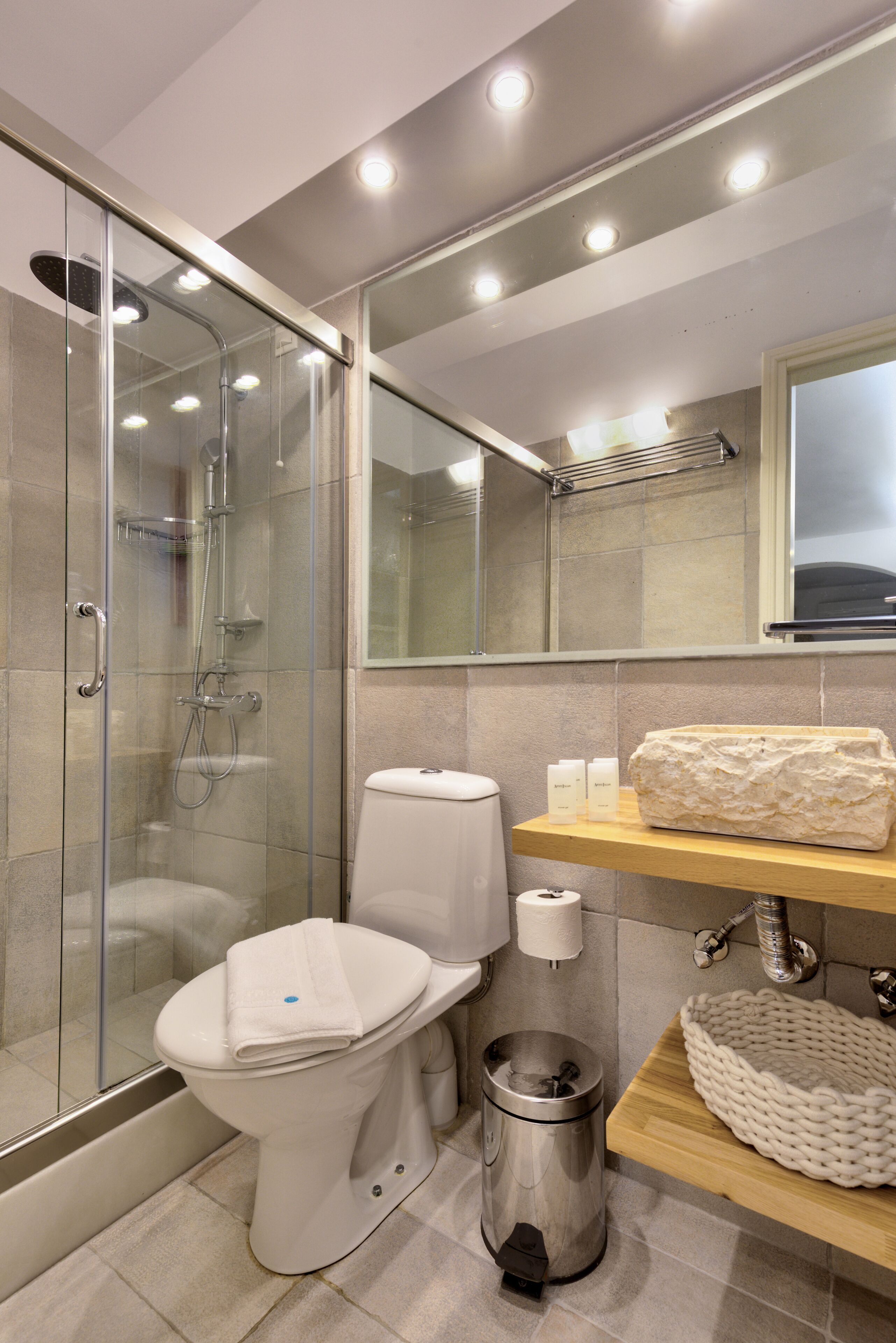 Un baño moderno con ducha envuelta en vidrio, inodoro, bidé y tocador con espejo y barra para toallas.