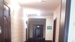 A hotel corridor with a red carpet, an EXIT sign, and a door marked 405-407. - Seoul hotel Mongolia (Ulaanbaatar)