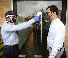 Un agente de seguridad verifica el documento de identidad de una persona en la entrada de un edificio.
