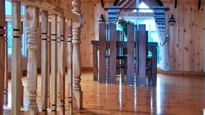 A wooden interior with a high ceiling, a staircase, and a view of the outdoors. - Cottage San Francesco (Nuwara Eliya)