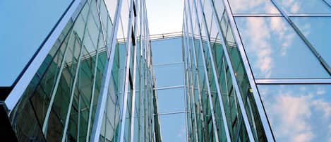 A modern glass building with a symmetrical facade and reflective surfaces.