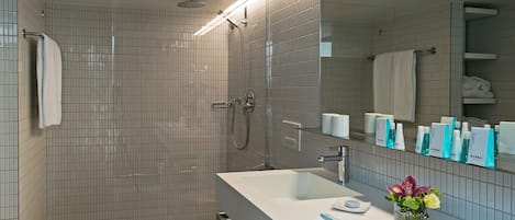 A modern bathroom with a shower, a sink, and a mirror.