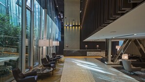 A spacious lobby with a reception desk, seating area, and a staircase. - Astoria Lucerne (Lucerne)