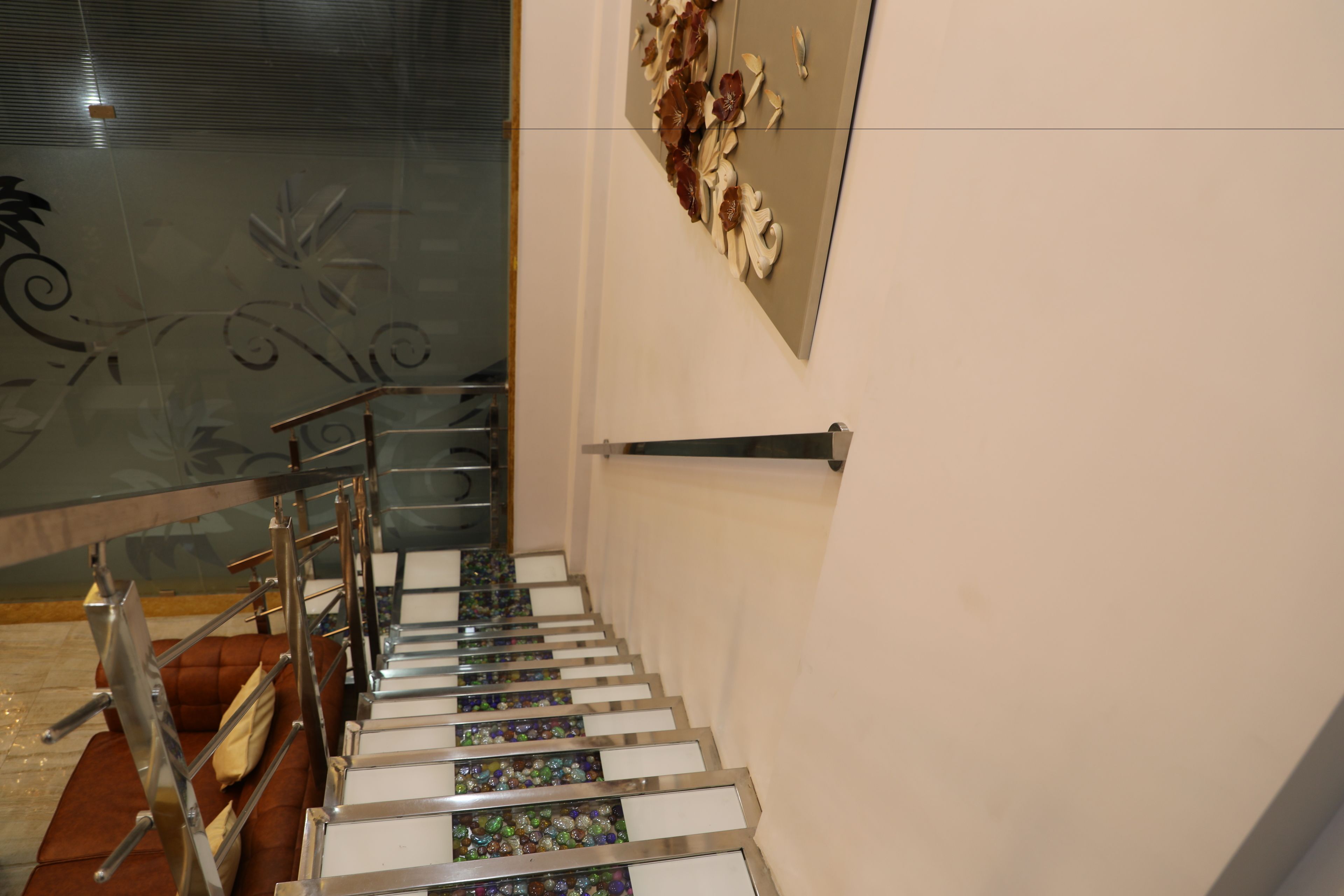 Eine Treppe mit Glasgeländer und einer dekorativen Wand.