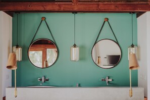 A bathroom with two sinks, each with a round mirror and a hanging light fixture. - MAJO Private Villas (Gili Trawangan)