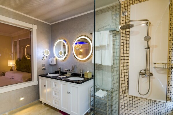 A modern bathroom with two sinks, a glass shower enclosure, and a vanity with a mirror. - Phoenicia Royal (Navodari)