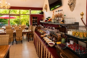 Zona de bufé con una variedad de alimentos y bebidas.