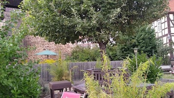 Un jardín con un banco de madera, una mesa y un cartel para Hotel & Café Schachtenburg.