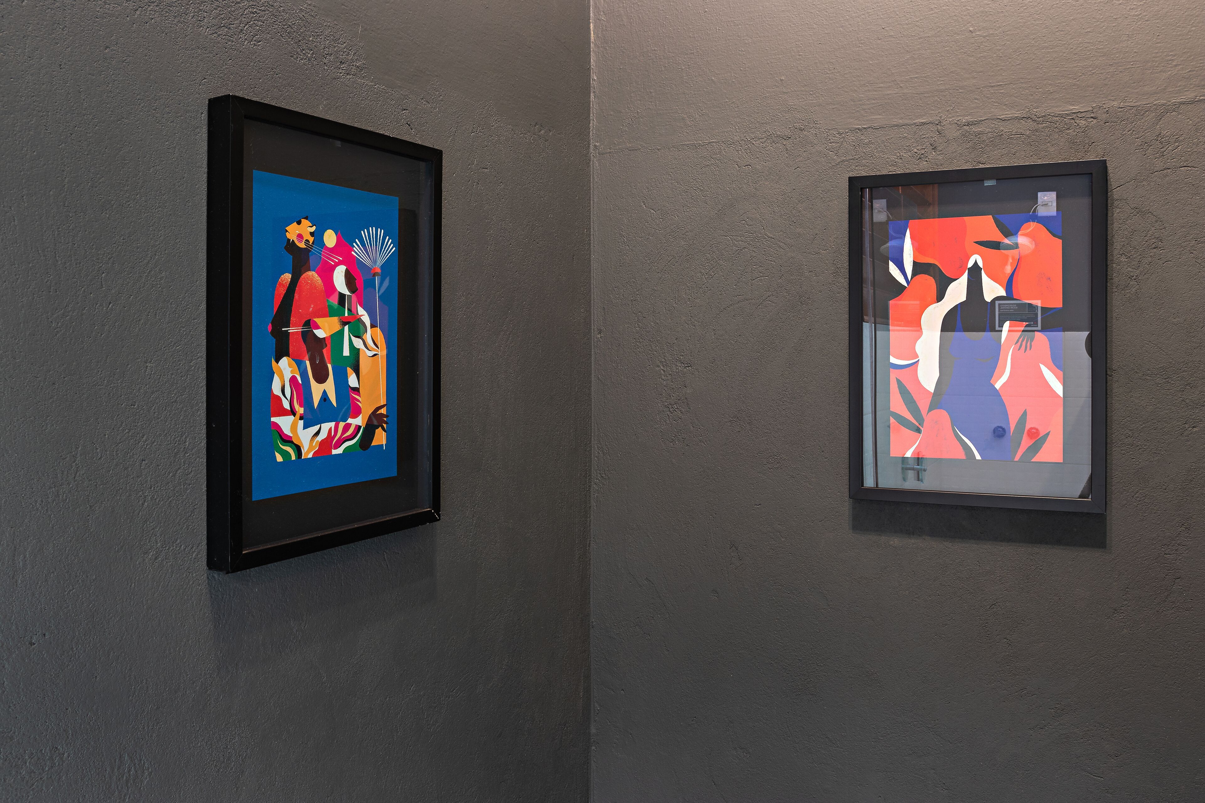 Dos obras de arte enmarcadas sobre una pared lisa.