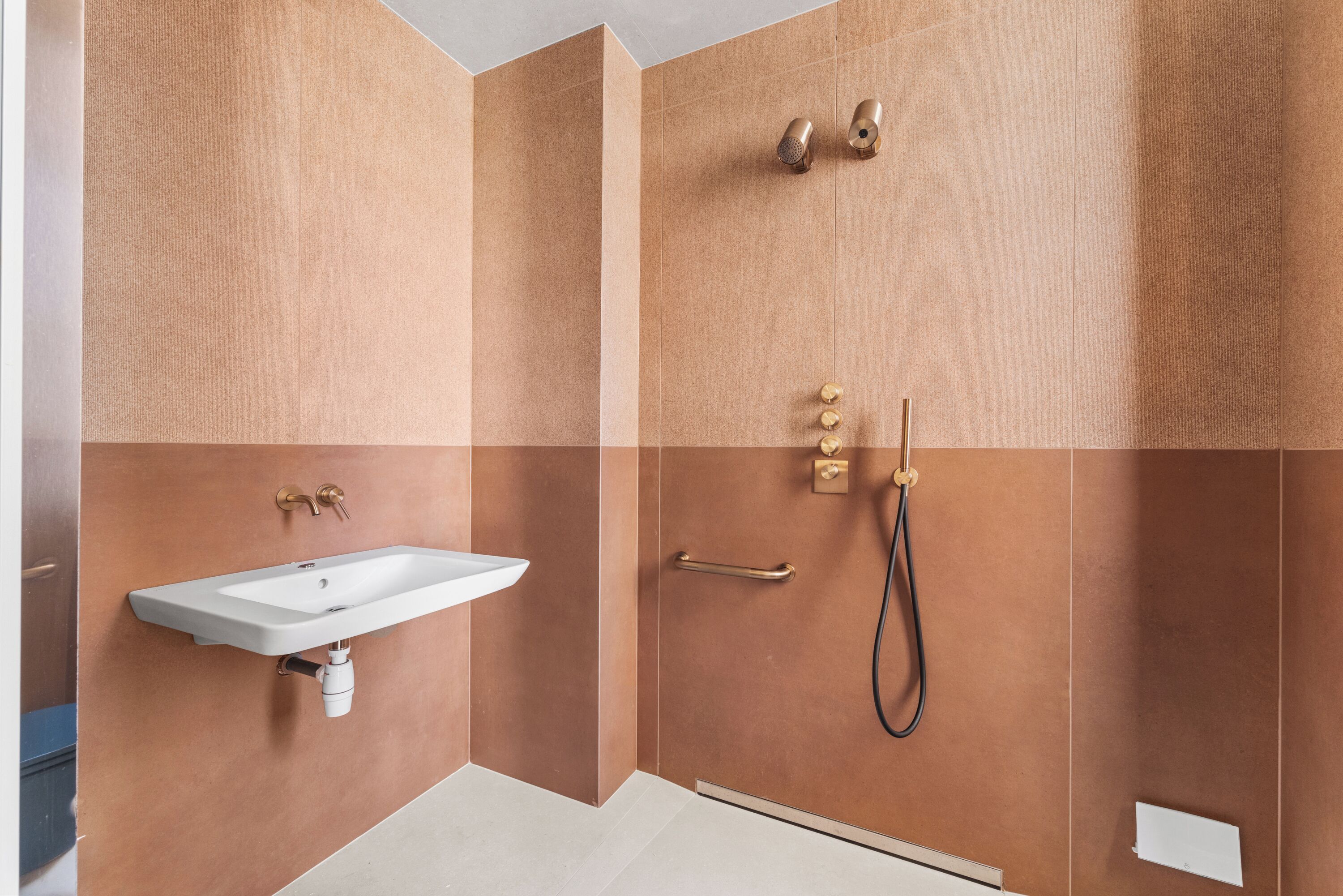 A bathroom with a sink, shower, and towel rack.