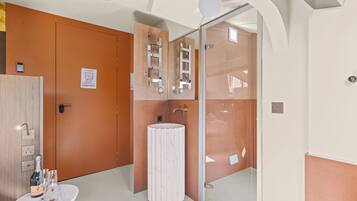 A modern bathroom with a marble sink, a mirror with a ladder design, and a wooden door.