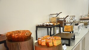 Um buffet com diversos produtos de panificação expostos em suportes de madeira.