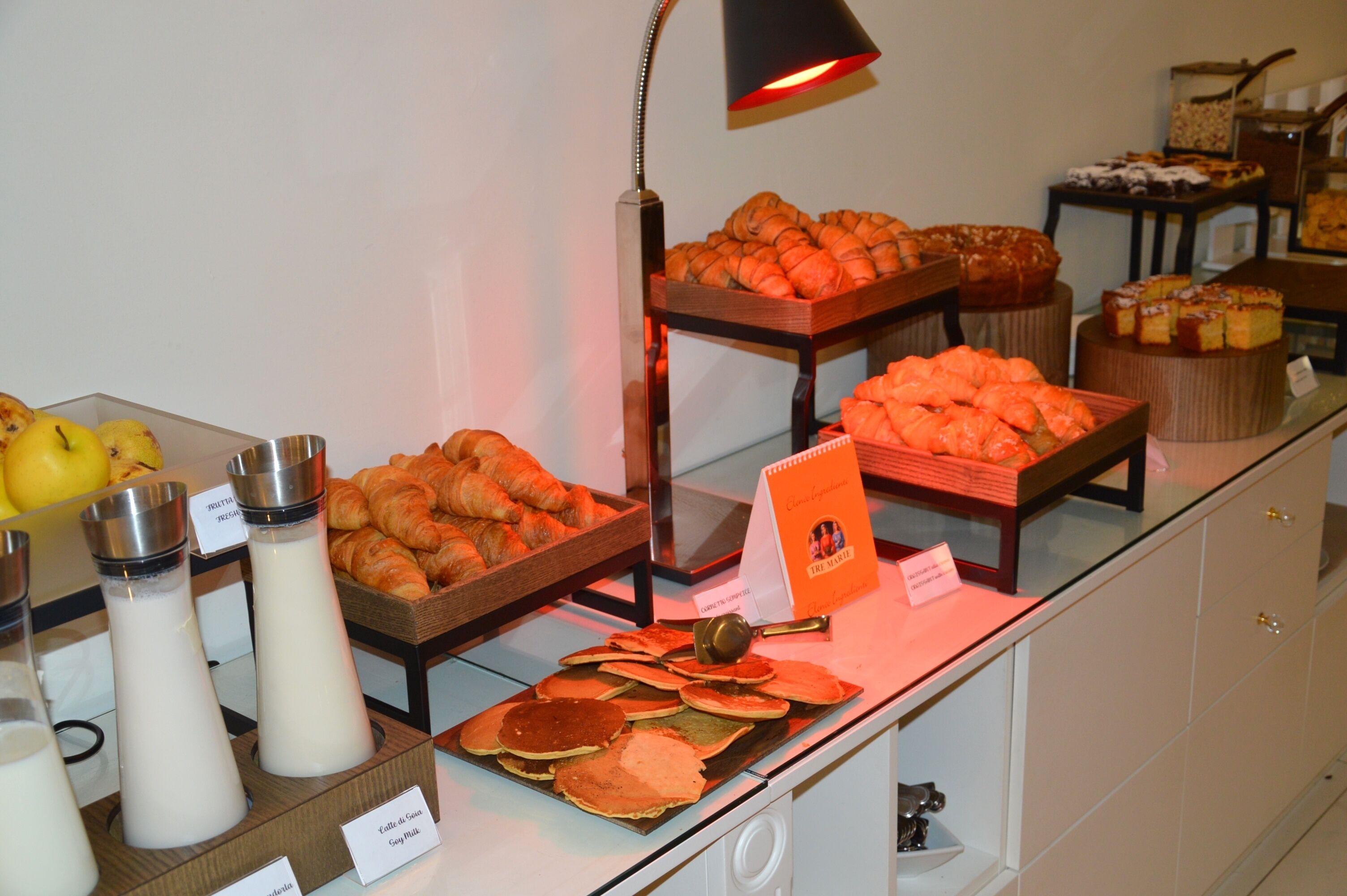 Een ontbijtbuffet met diverse gerechten, waaronder gebak, fruit en drankjes.