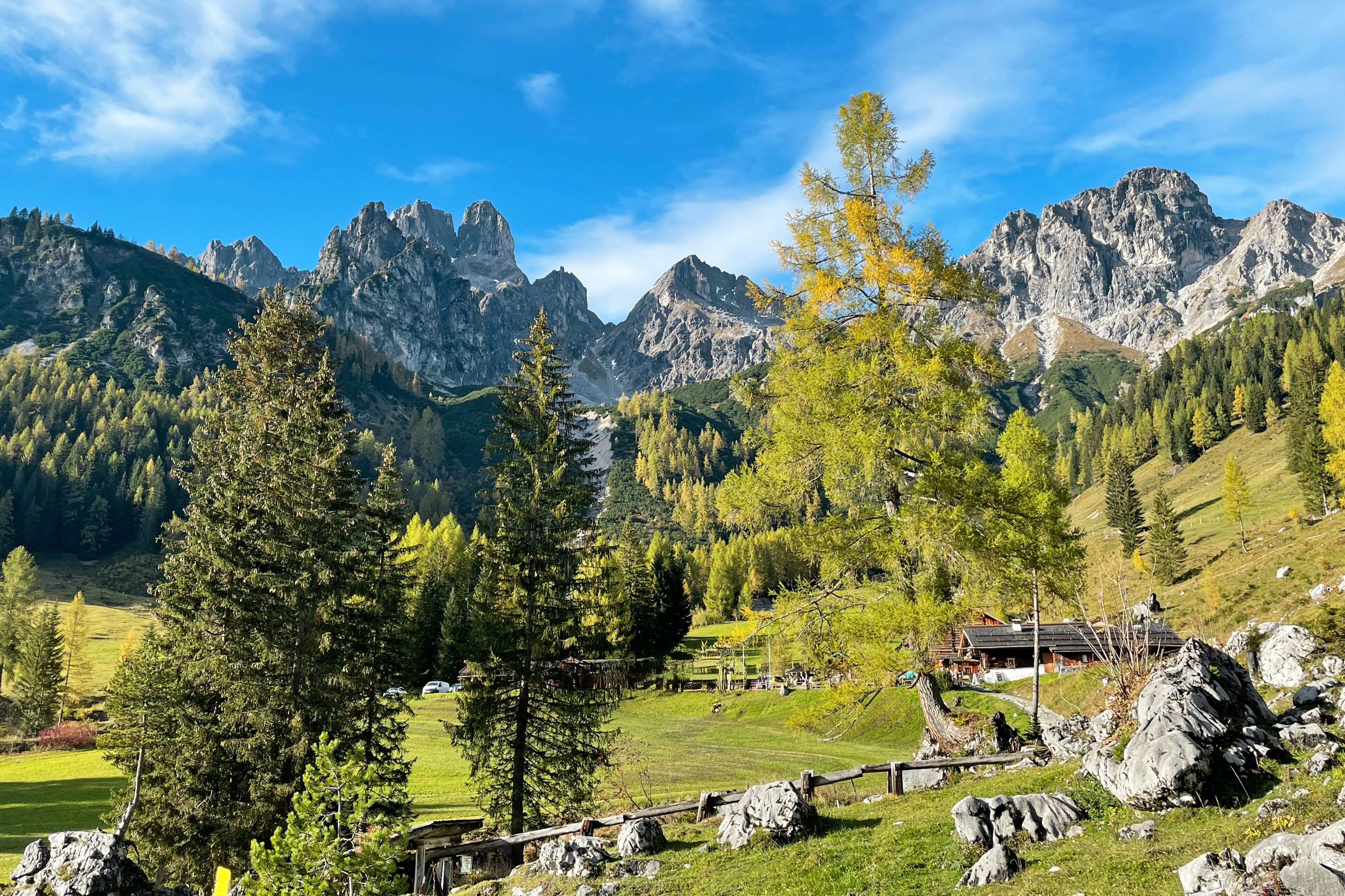 A mountainous landscape with a house surrounded by trees and rocks.