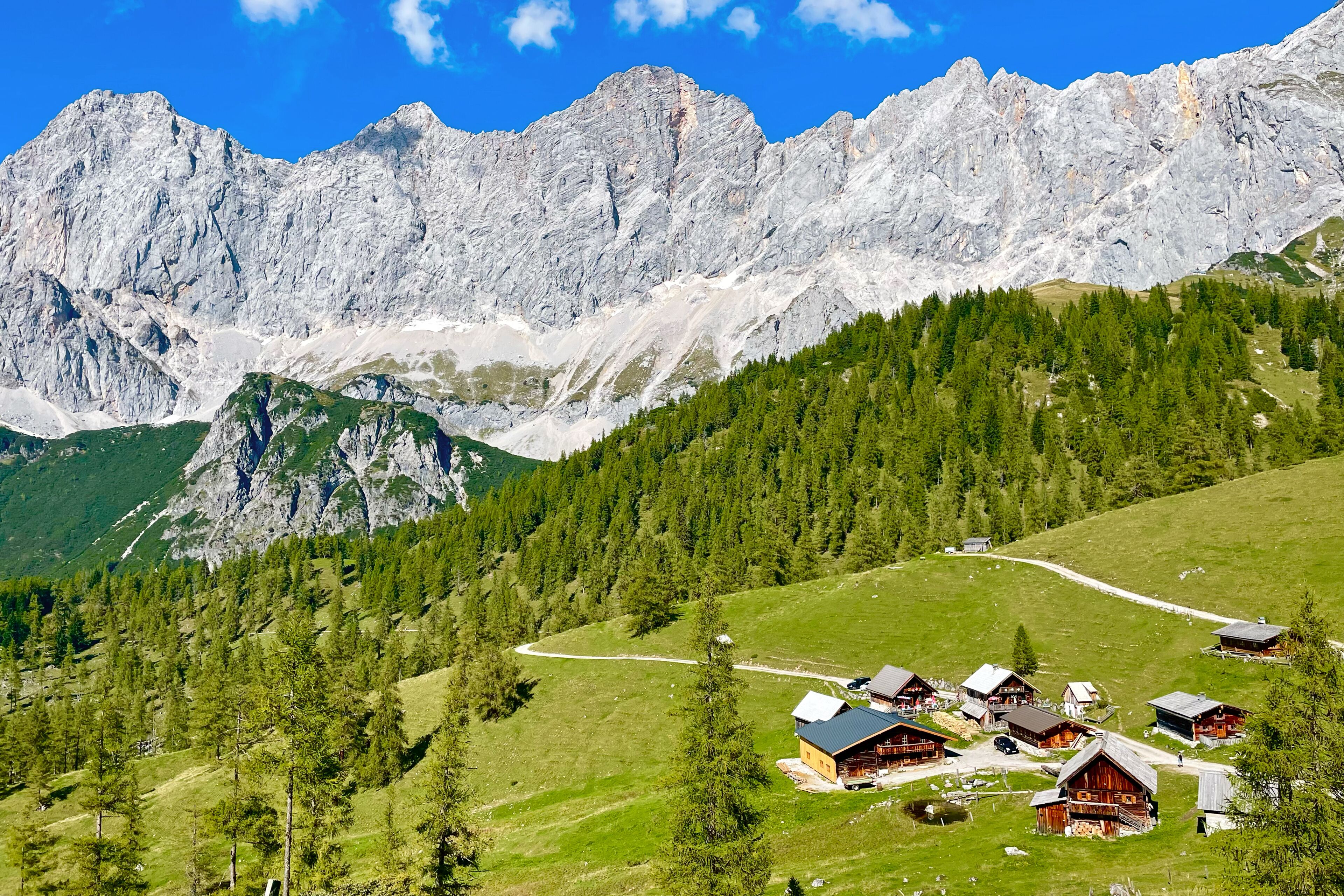 A mountainous landscape with a cluster of wooden cabins.