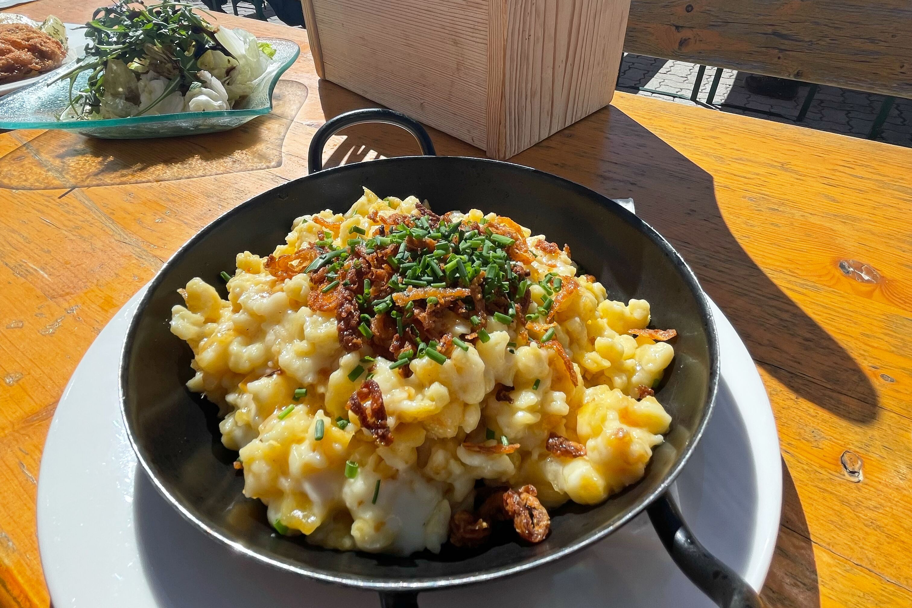 Une table à manger avec un plat de nourriture, une assiette et une boîte en bois.