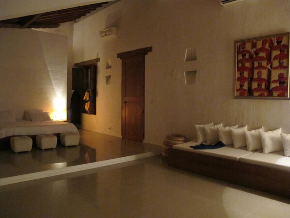 A hotel room with a bed, a sofa, and a wall-mounted artwork. - Portal de la Marquesa (Mompos)