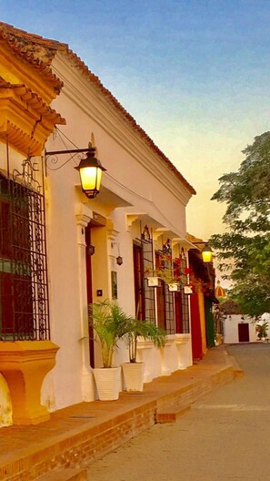 A traditional building with a white facade, multiple doors, and a tiled roof. - Portal de la Marquesa (Mompos)